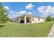 Expansive backyard with healthy lawn, covered patio area, offers ample space for recreation at 115 Duchess Rd, Deland, FL 32724