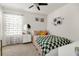 This cozy bedroom features a ceiling fan, a large window with sheer curtains, and ample storage at 115 Duchess Rd, Deland, FL 32724