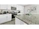Modern kitchen featuring an island with granite countertop, stainless steel appliances, and white cabinets at 115 Duchess Rd, Deland, FL 32724