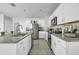 Modern kitchen features sleek white cabinetry, granite countertops, stainless steel appliances, and an island with seating at 115 Duchess Rd, Deland, FL 32724