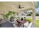 Covered patio with a ceiling fan, wood table set, and outdoor grill provides a comfortable outdoor space at 115 Duchess Rd, Deland, FL 32724