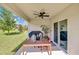 Relaxing patio with ceiling fan, wood table set, and outdoor grill offers a comfortable outdoor space at 115 Duchess Rd, Deland, FL 32724