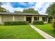 Close up of a cute single-story home with a lush lawn and mature trees, showcasing its curb appeal at 1171 Covewood Trl, Maitland, FL 32751