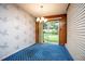Cozy room featuring fern wallpaper, sliding glass doors to the backyard, and paneled walls at 1171 Covewood Trl, Maitland, FL 32751