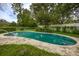 A kidney-shaped pool is in the backyard, surrounded by mature landscaping and a tall white fence at 1171 Covewood Trl, Maitland, FL 32751