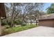 Serene backyard with mature trees, a glimpse of the lake, and a spacious patio at 137 Hickory Ridge Cir, Lake Mary, FL 32746
