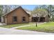 View of the side and front of a brown home with green lawn, walkway, and mature trees at 137 Hickory Ridge Cir, Lake Mary, FL 32746