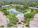 Stunning aerial view of a community with a sparkling lake, lush greenery, a pool, and well-maintained residential buildings at 14 Escondido Ct # 134, Altamonte Springs, FL 32701