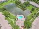 Gorgeous aerial view of a community featuring a serene lake, sparkling pool, clubhouse, and lush green spaces at 14 Escondido Ct # 134, Altamonte Springs, FL 32701