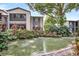 Beautiful community pond with mature trees, landscaping, and fountain features at 14 Escondido Ct # 134, Altamonte Springs, FL 32701