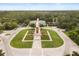 Aerial view of a manicured town center with a distinctive clock tower and community building surrounded by trees at 14474 Prunningwood Pl, Winter Garden, FL 34787
