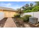 Backyard with a brick path, flowering tree and an air conditioning unit at 14474 Prunningwood Pl, Winter Garden, FL 34787