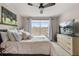 Cozy bedroom featuring a large window, ceiling fan and TV at 14474 Prunningwood Pl, Winter Garden, FL 34787