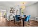 Elegant dining room featuring wood floors, stylish blue chairs, and abundant natural light from the windows at 14474 Prunningwood Pl, Winter Garden, FL 34787