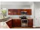 Well-lit kitchen with stainless steel appliances, granite countertops, and dark wood cabinets at 14474 Prunningwood Pl, Winter Garden, FL 34787