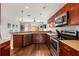 Modern kitchen features stainless steel appliances, ample counter space, and stylish dark wood cabinetry at 14474 Prunningwood Pl, Winter Garden, FL 34787