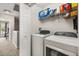 Convenient laundry room equipped with a washer, dryer and shelving at 14474 Prunningwood Pl, Winter Garden, FL 34787
