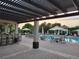 A covered patio with tables, umbrellas, chairs and a swimming pool in the background at 14474 Prunningwood Pl, Winter Garden, FL 34787