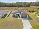 Stunning aerial view of home featuring a spacious lawn, gray roof, brown garage door, and long driveway at 16730 Sw 50Th Cir, Ocala, FL 34473