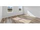 Sunlit bedroom showcasing wood-look floors and two windows offering natural light at 16730 Sw 50Th Cir, Ocala, FL 34473