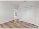Bedroom with wood-look floors, closet doors, and doorway view of kitchen appliances at 16730 Sw 50Th Cir, Ocala, FL 34473