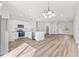Bright, all white kitchen features stainless steel appliances, pendant lighting, and an island with seating at 16730 Sw 50Th Cir, Ocala, FL 34473