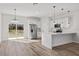 Bright kitchen with stainless steel appliances, quartz countertop, pendant lights, and an open concept to living area at 16730 Sw 50Th Cir, Ocala, FL 34473