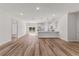 A well-lit open-concept living and kitchen space showcasing wood floors and modern white finishes at 16730 Sw 50Th Cir, Ocala, FL 34473