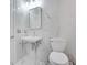 Modern bathroom featuring marble walls, pedestal sink, and toilet for a clean, stylish look at 1810 Oakbrook Dr, Longwood, FL 32779