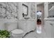 Well-decorated white bathroom with a leaf-patterned wallpaper and a sleek toilet at 1810 Oakbrook Dr, Longwood, FL 32779