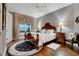 Bedroom featuring a large window with decorative curtains, wooden floors and area rug at 1810 Oakbrook Dr, Longwood, FL 32779
