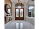 Bright foyer with marble floors and a decorative mirror; the double doors let in natural light at 1810 Oakbrook Dr, Longwood, FL 32779