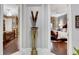 Hallway with a decorative sculpture flanked by views into beautifully appointed bedrooms at 1810 Oakbrook Dr, Longwood, FL 32779
