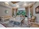 The bright and spacious living room features custom drapery, elegant sofas, and an ornate coffee table at 1810 Oakbrook Dr, Longwood, FL 32779