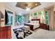 Beautiful bedroom features a decorative ceiling, large windows, sitting area, and ensuite bath at 1810 Oakbrook Dr, Longwood, FL 32779