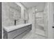 Bathroom featuring double sinks, modern faucets, a seamless glass shower, and marble accents at 1850 Shawnee Trl, Maitland, FL 32751