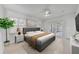 Bright bedroom with a gray upholstered bed, and a plant, filled with natural light and modern accents at 1850 Shawnee Trl, Maitland, FL 32751