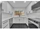 Modern kitchen featuring white cabinets, sleek countertops, and stainless steel appliances with black marble flooring at 1850 Shawnee Trl, Maitland, FL 32751