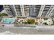 Aerial view of a luxury condo building highlighting its pool, deck, and beach access at 1925 S Atlantic Ave # 411, Daytona Beach, FL 32118