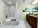 Modern bathroom with white marble tile, a shower-tub combination, and updated vanity at 1925 S Atlantic Ave # 411, Daytona Beach, FL 32118