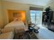 Comfortable bedroom with a window view, relaxing chair and footrest, and cozy interior design at 1925 S Atlantic Ave # 411, Daytona Beach, FL 32118