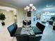 A modern dining area with glass table, black chairs, and a stylish chandelier and access to the balcony at 1925 S Atlantic Ave # 411, Daytona Beach, FL 32118