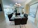 A sun-drenched dining room with a clear glass table and black chairs, complemented by a modern chandelier at 1925 S Atlantic Ave # 411, Daytona Beach, FL 32118
