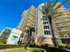 A luxurious beachfront building with beautiful architecture on a sunny day with palm trees at 1925 S Atlantic Ave # 411, Daytona Beach, FL 32118