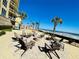 Outdoor fire pit area with Adirondack chairs, palm trees, and ocean views in a beautifully landscaped space at 1925 S Atlantic Ave # 411, Daytona Beach, FL 32118