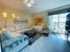 Cozy room featuring a comfortable sofa, a tucked away bed nook, and access to a balcony with water views at 1925 S Atlantic Ave # 411, Daytona Beach, FL 32118