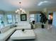Bright living room features stylish white furniture, tile floors, lots of natural light, and views at 1925 S Atlantic Ave # 411, Daytona Beach, FL 32118