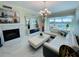 Bright living room featuring a fireplace, modern lighting, white couches, and floor-to-ceiling windows with a view at 1925 S Atlantic Ave # 411, Daytona Beach, FL 32118