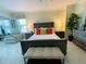 Bright main bedroom featuring stylish furniture, including a bed, dresser, chairs, and ceiling fan at 1925 S Atlantic Ave # 411, Daytona Beach, FL 32118