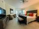 Bright main bedroom featuring stylish furniture, including a bed, dresser, chairs, and ceiling fan at 1925 S Atlantic Ave # 411, Daytona Beach, FL 32118